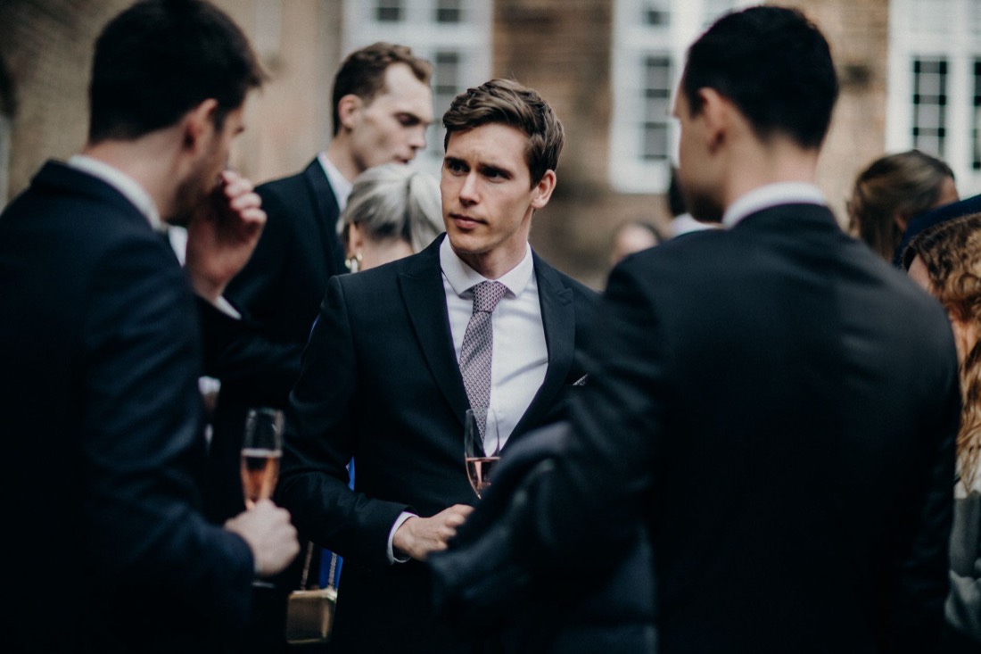 Colleagues in suits talking at a company reception